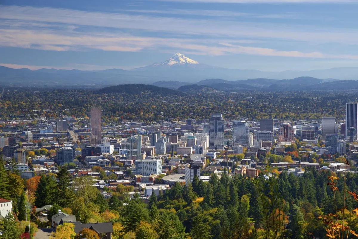 A scenic view of the downtown skyline and Mount Hood framed by fall foliage and rich greenery. The image invites ideas of nearby adventures, scenic drives, and the broader regional beauty accessible during a stay at Cukoo's Nest.