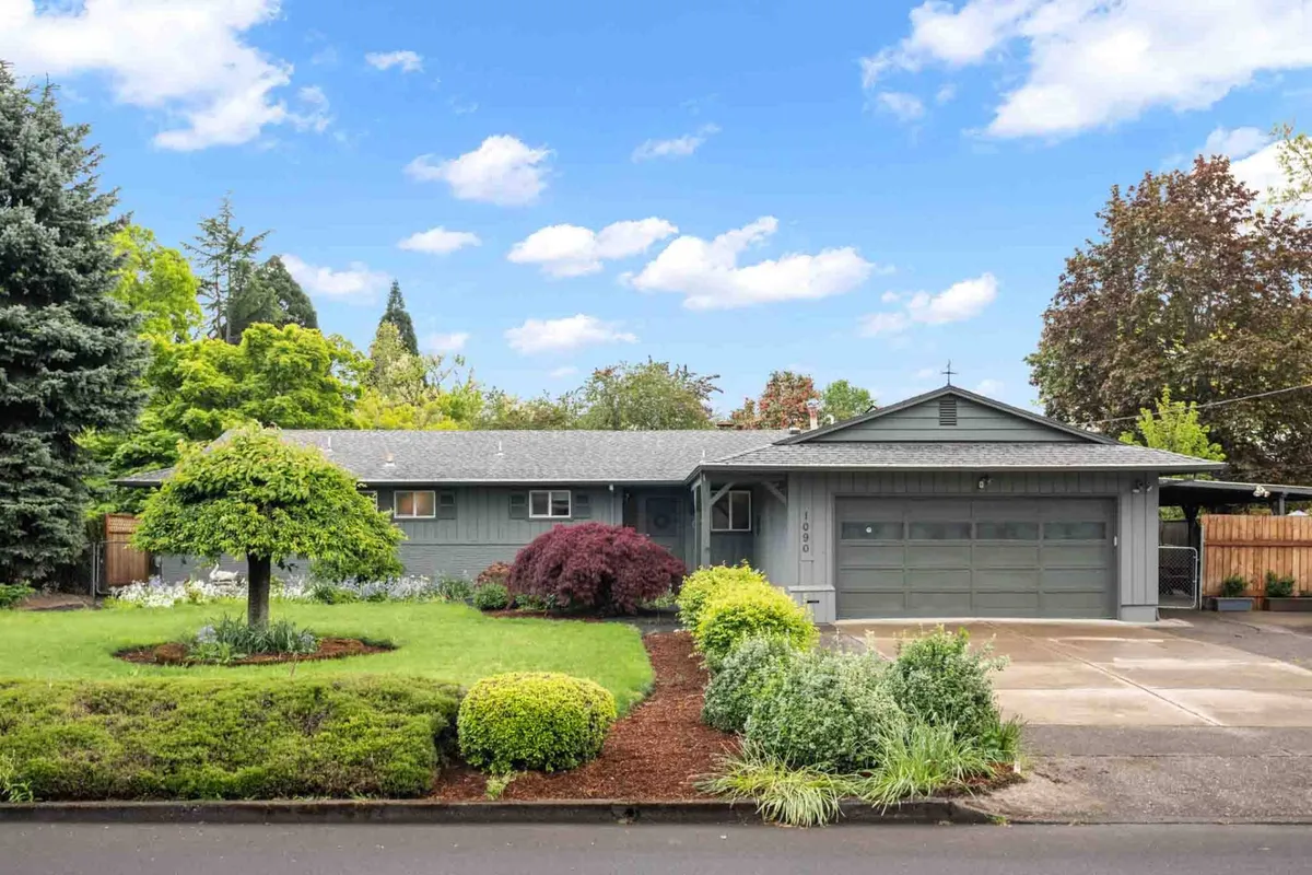 A well-kept front exterior view of the home, showcasing a manicured lawn, colorful shrubs, and a modern garage door. The scene exudes a sense of residential tranquility and excellent curb appeal, hinting at the home's quiet, comfortable setting.