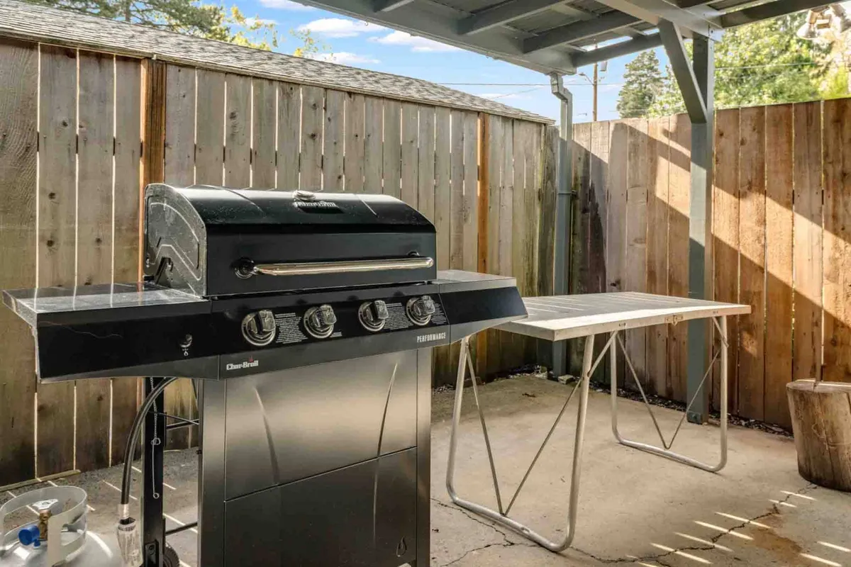 The photo highlights an outdoor grill and prep table against a wooden fence, evoking the essence of backyard barbecues and gatherings. The setup is simple yet inviting, perfect for cooking and socializing outdoors with family and friends after a day of adventure.
